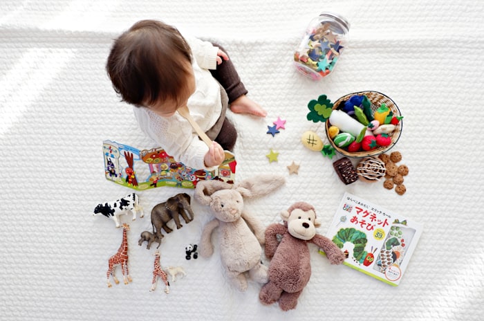 A child happily surrounded by toys