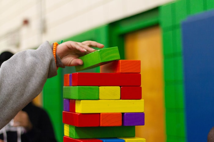 Hands stacking colorful building blocks