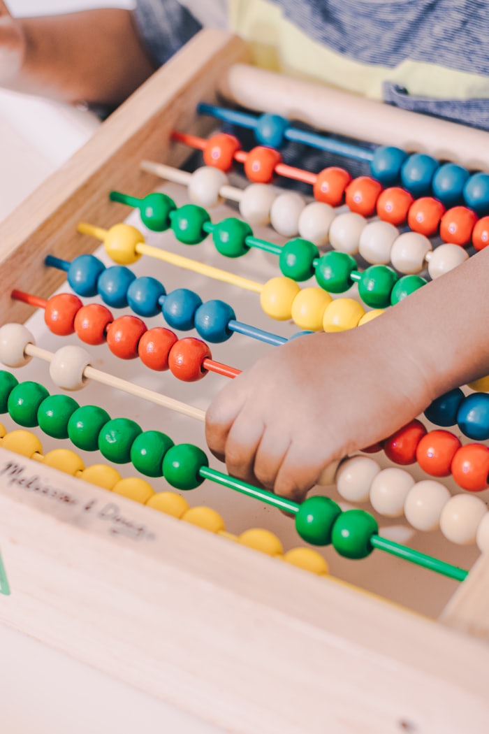 A child learning with a colorful counting abacus