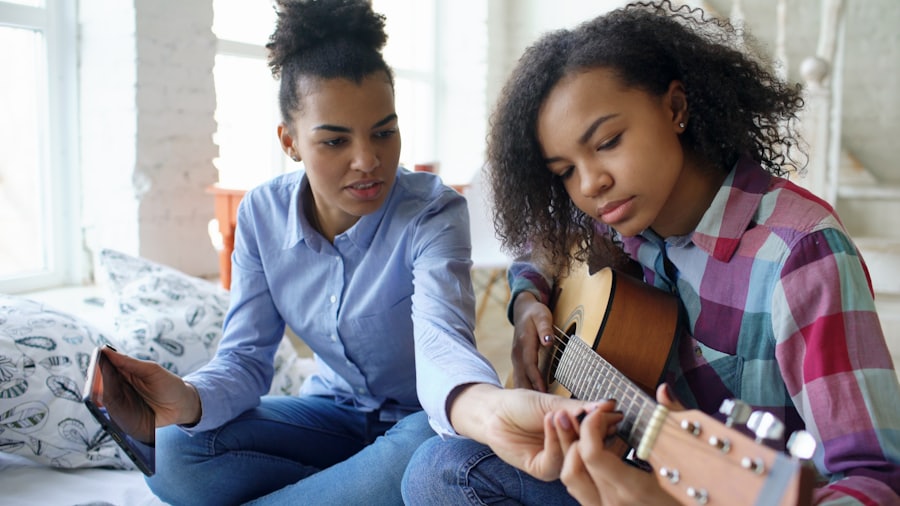 A mentor helping a teen learn to play guitar